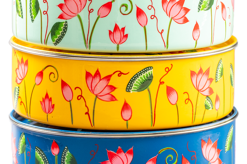 Stack of different color masala dabbas.