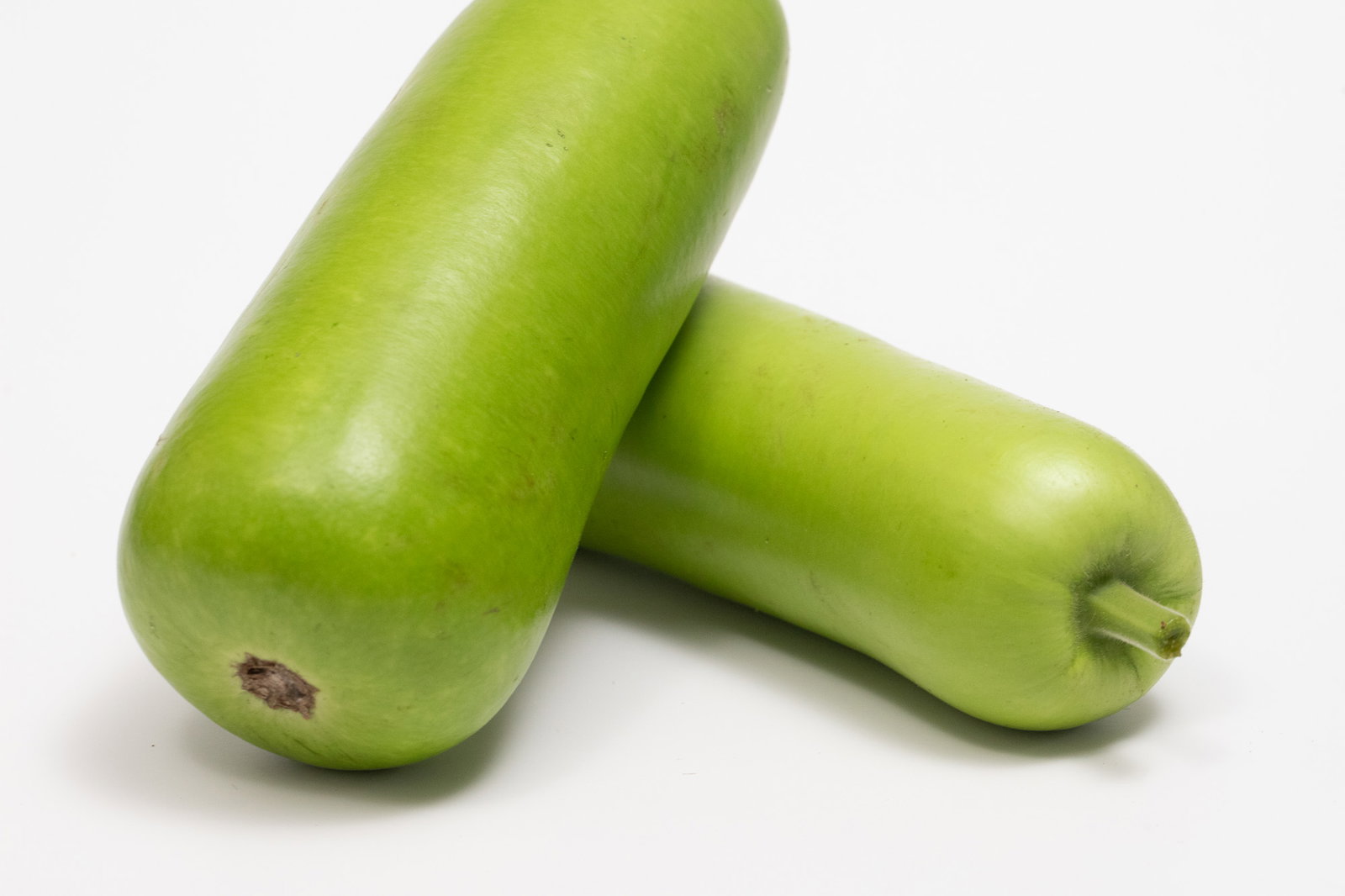 Two dudhi fruits, stacked.